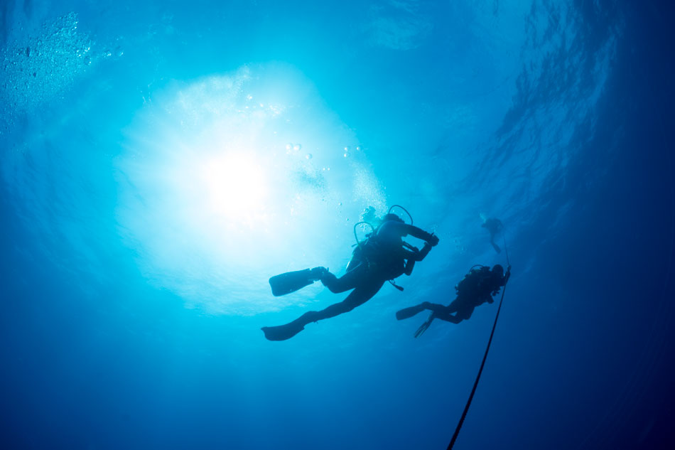two-silhouetted-divers - decompression sickness - scuba diving - scubly