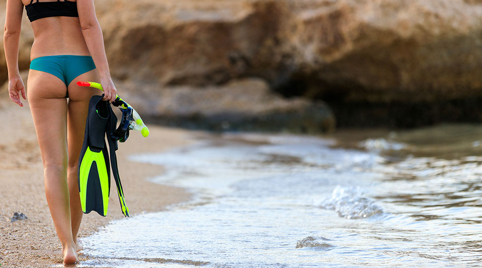 scuba gear accessories - woman walking on beach - scubly